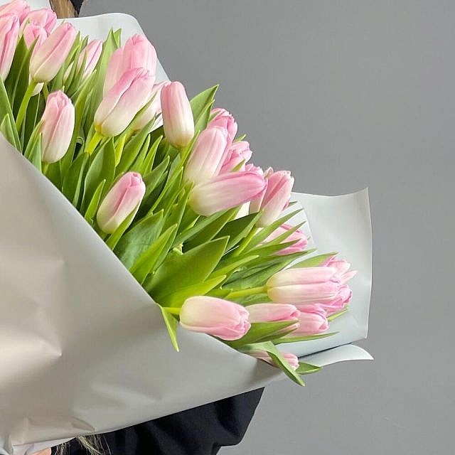 Букет 51 тюльпан Pale Pink в упаковке в руках сбоку