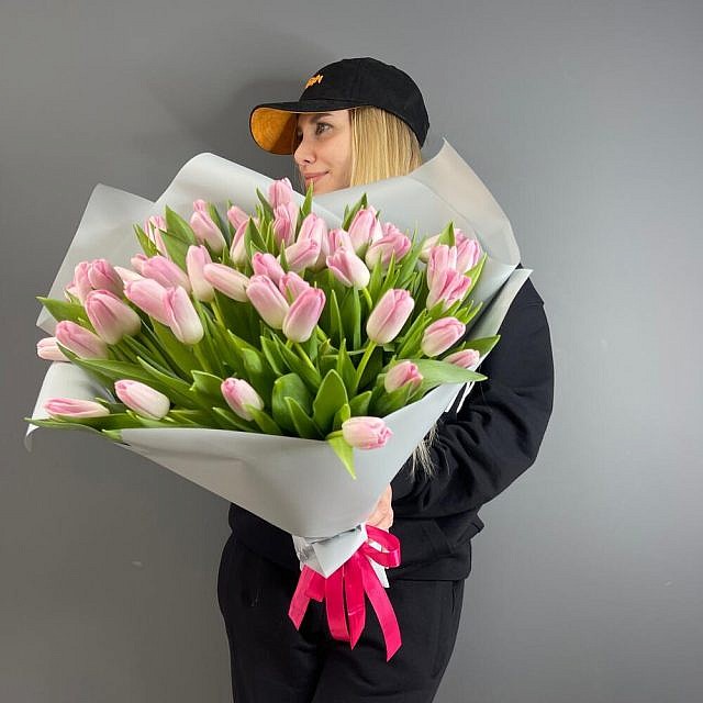 Букет 51 тюльпан Pale Pink в упаковке в руках прямо